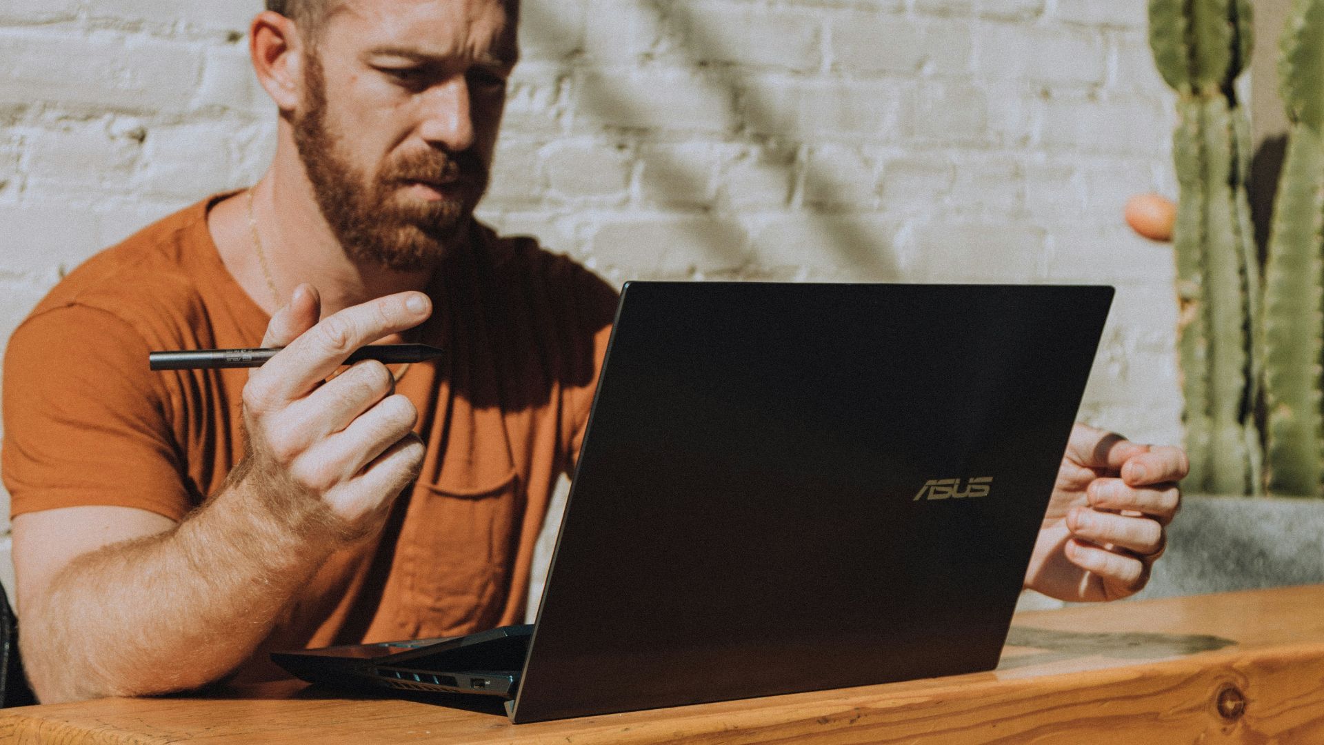 a man sitting at a table using a laptop computer