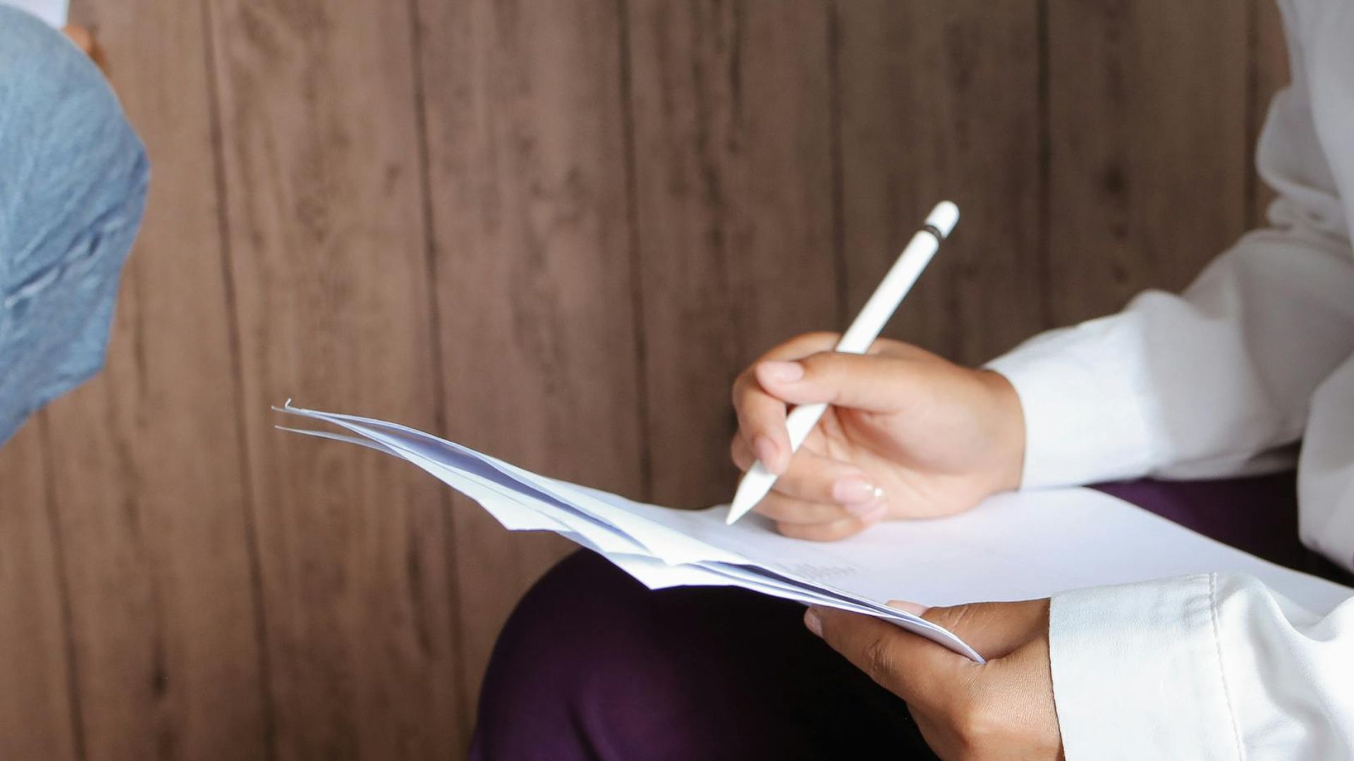 Two women collaborating indoors, focused on documents in a casual setting.