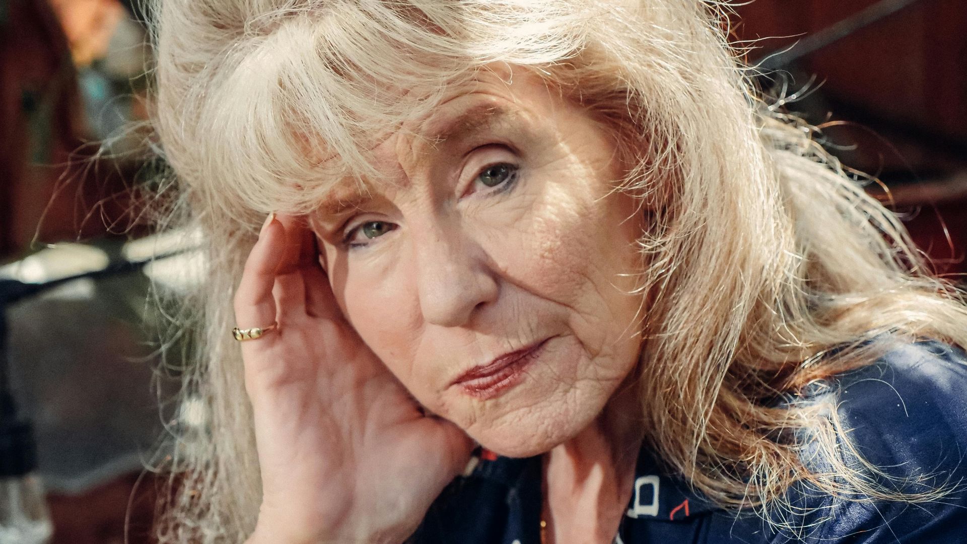 Portrait of a senior woman in blue, exuding thoughtful reflection and elegance.