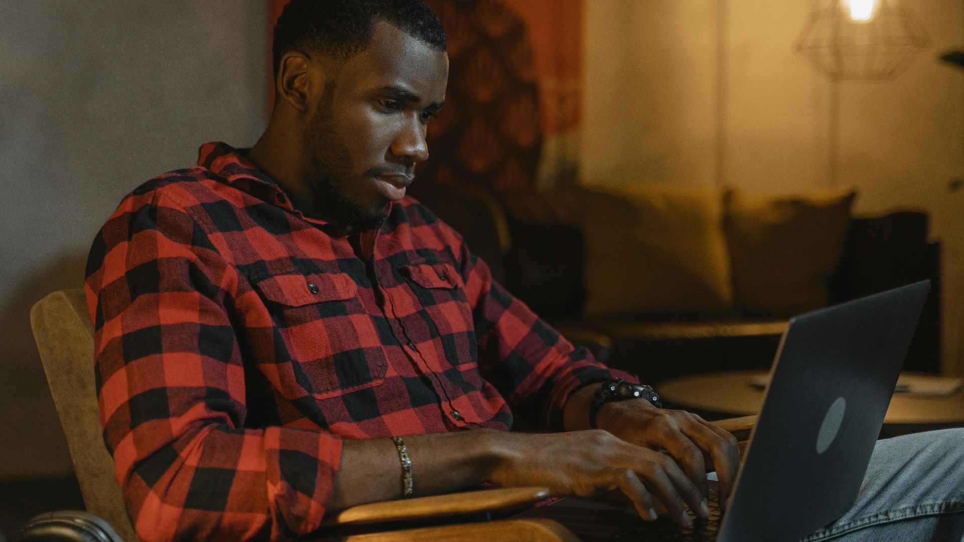 Contemporary scene of a man working on a laptop in a cozy home environment, highlighting remote work lifestyle.
