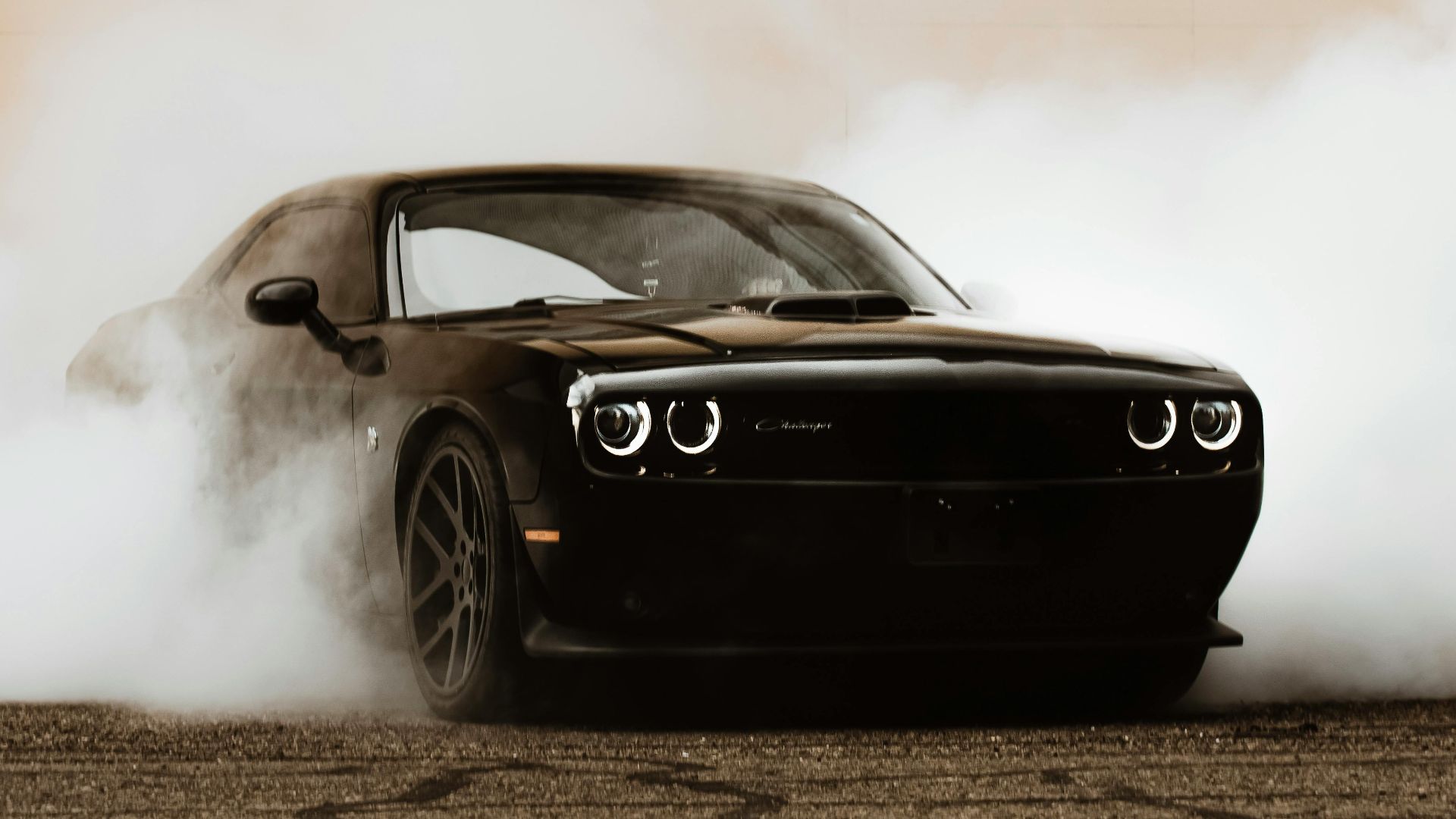 Stunning black Dodge Challenger SRT Demon performs a dramatic smoke drift, showcasing power and style.