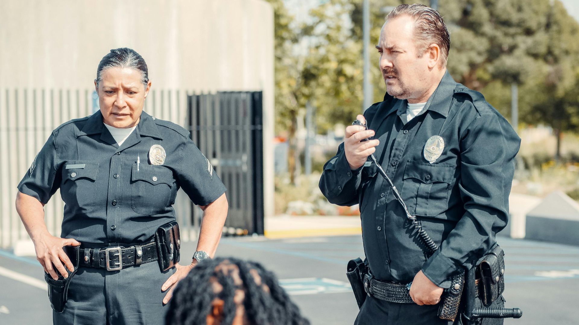 Two police officers interacting at a crime scene, focusing on communication and law enforcement duties.