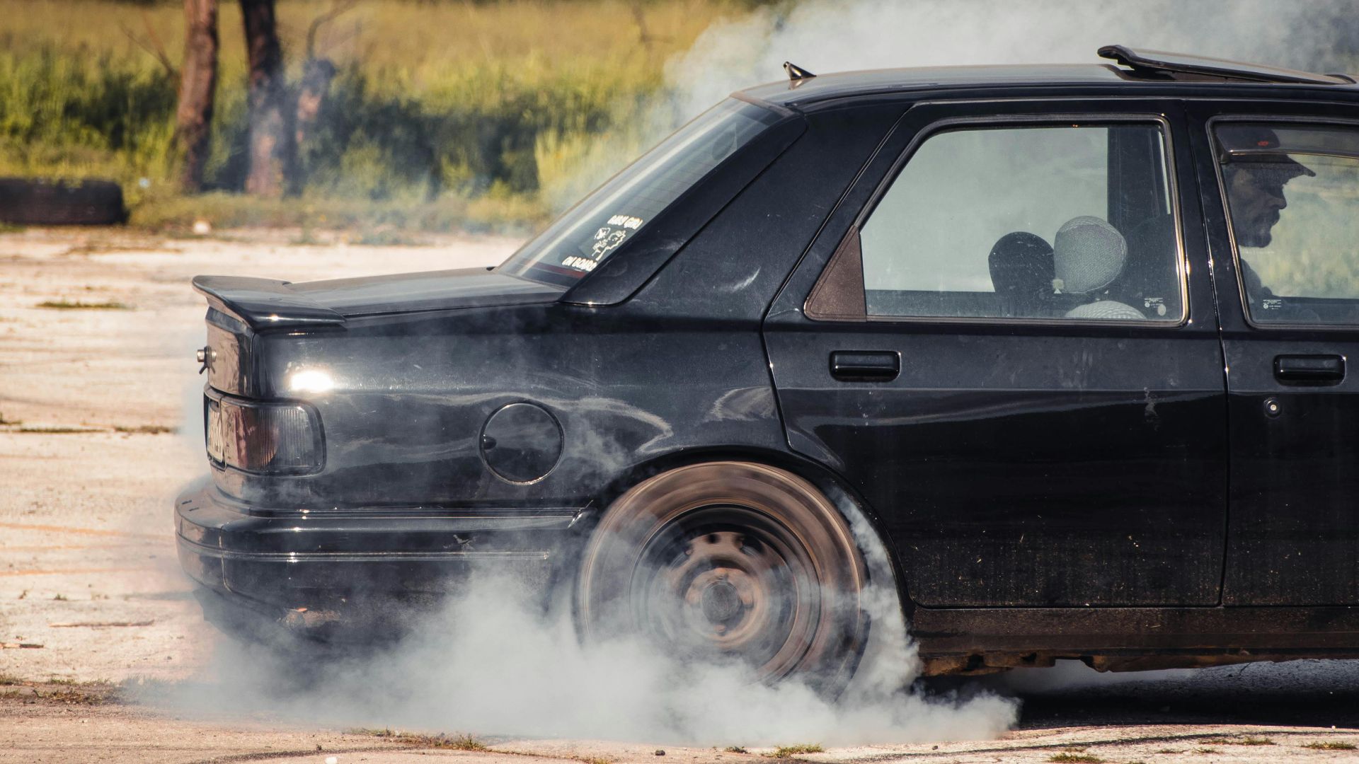 A classic sedan performing a thrilling drift during a car meet in Sarajevo.