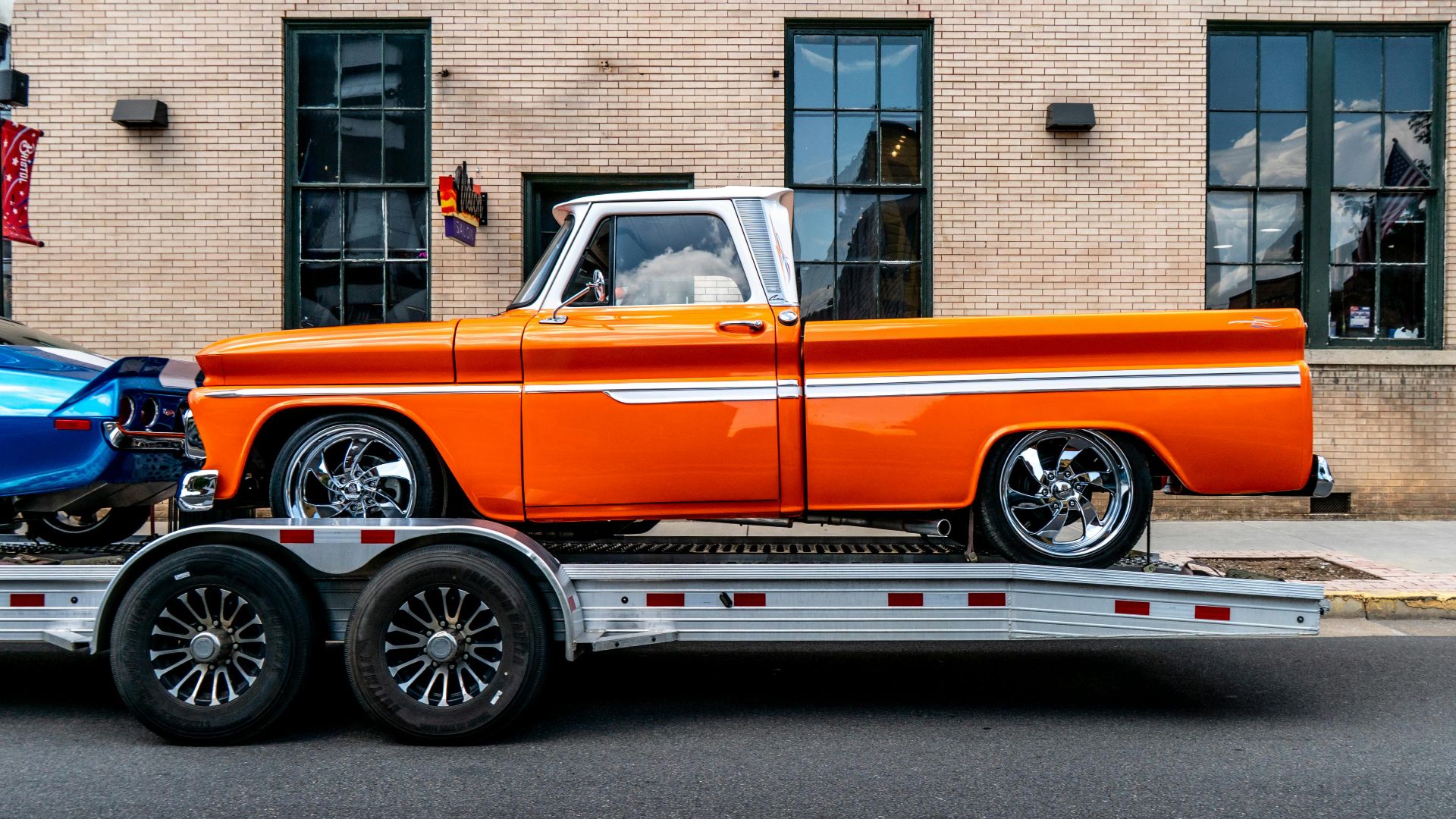 Classic orange pickup truck on trailer in front of brick building, Bristol, Tennessee.