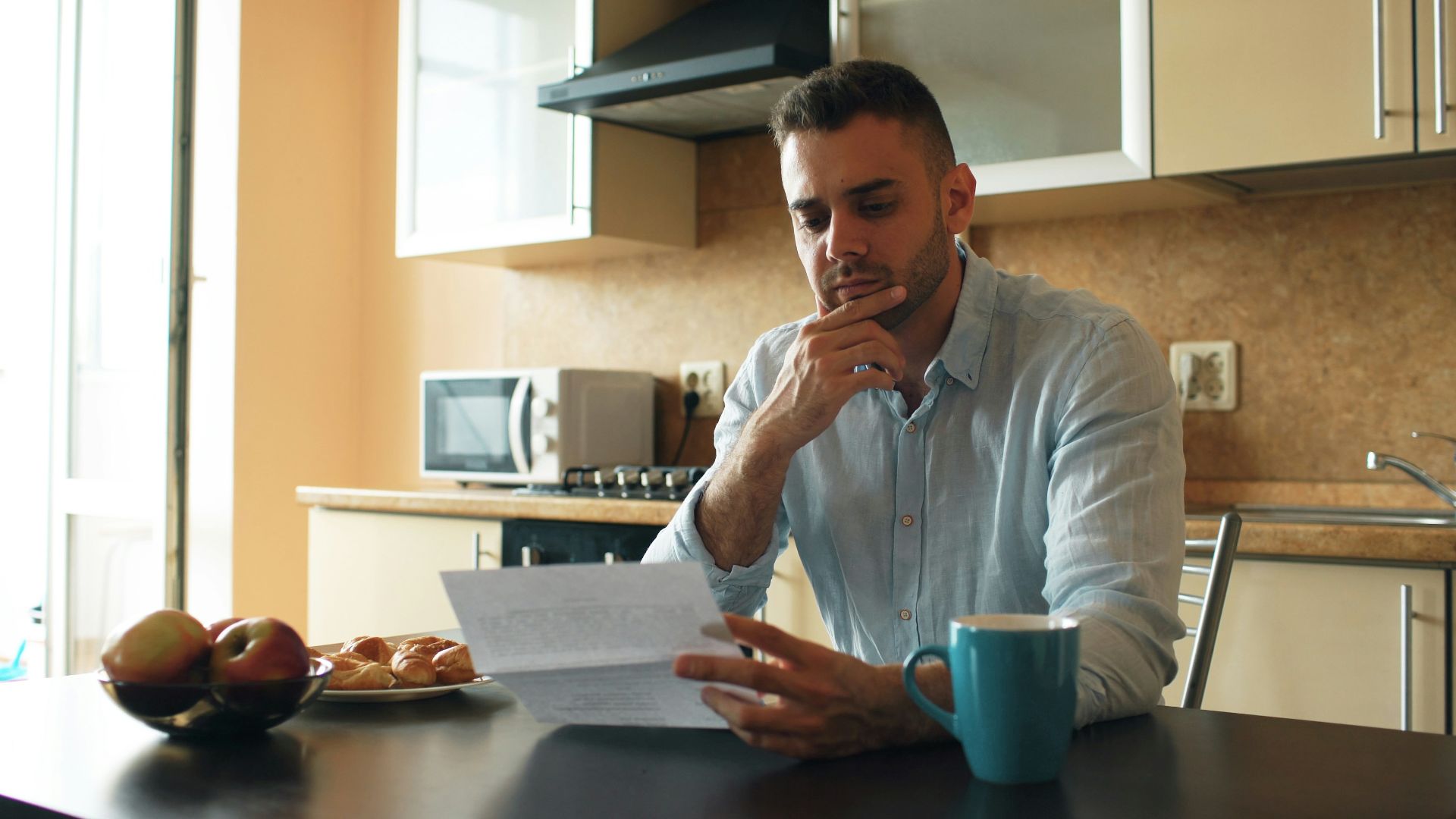 Man reading a document in a kitchen