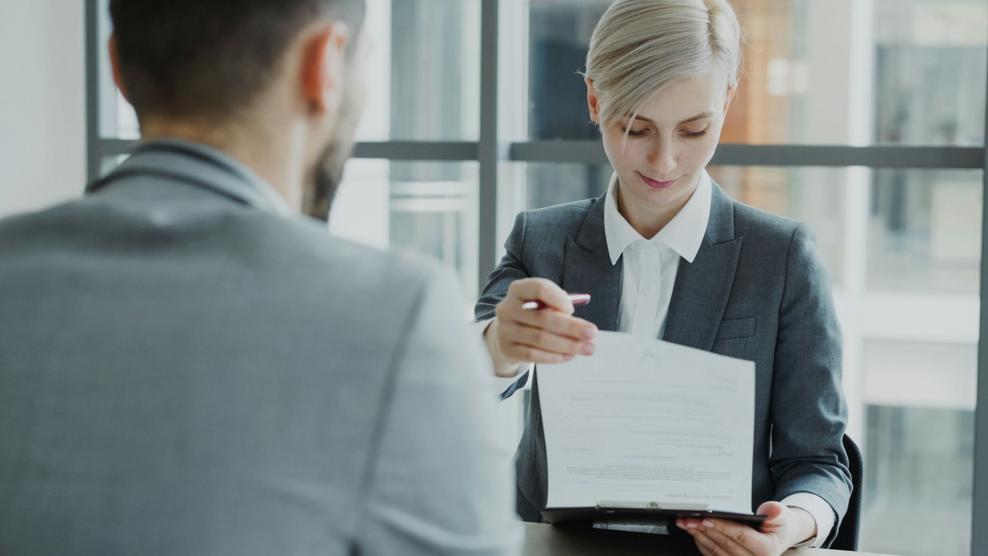 Woman in suit shows document to man
