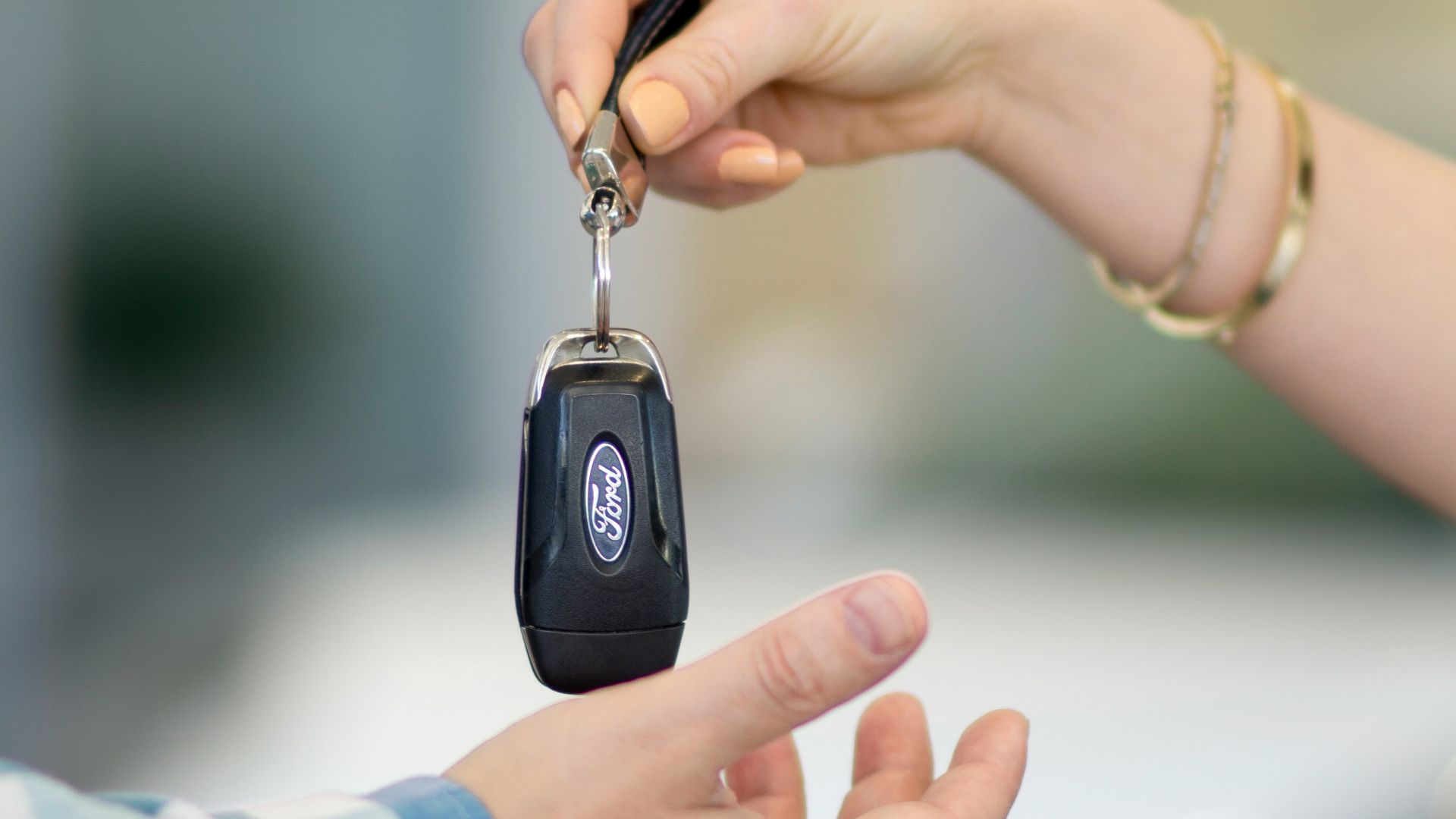 A person handing a car key to another person