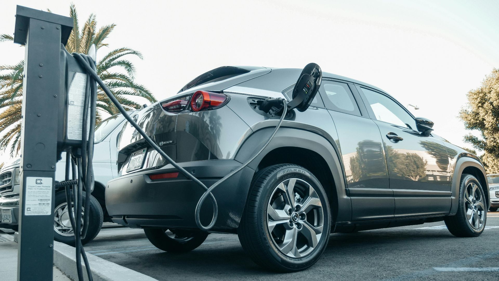 Modern electric vehicle charging at an outdoor station in daylight.