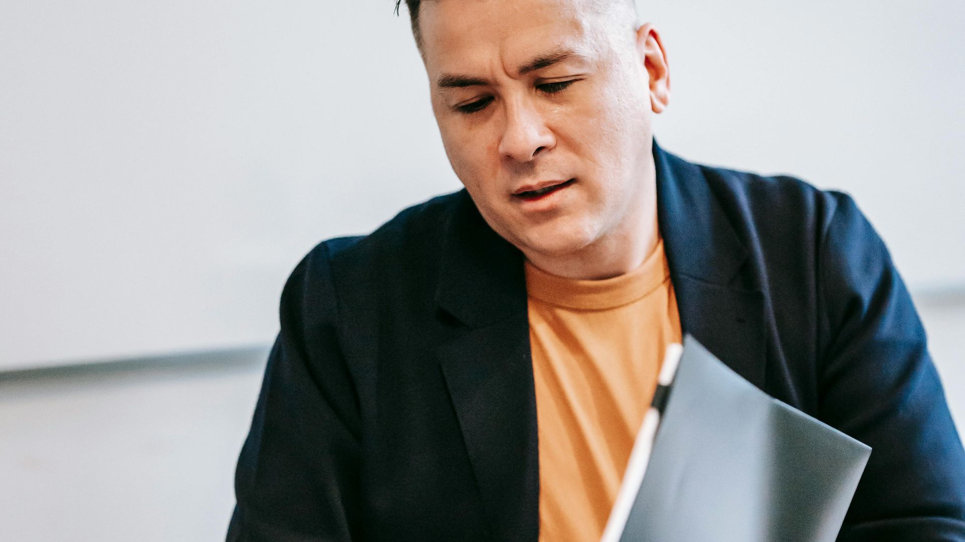 Businessman in a suit reviewing documents at an office desk, focused on work.