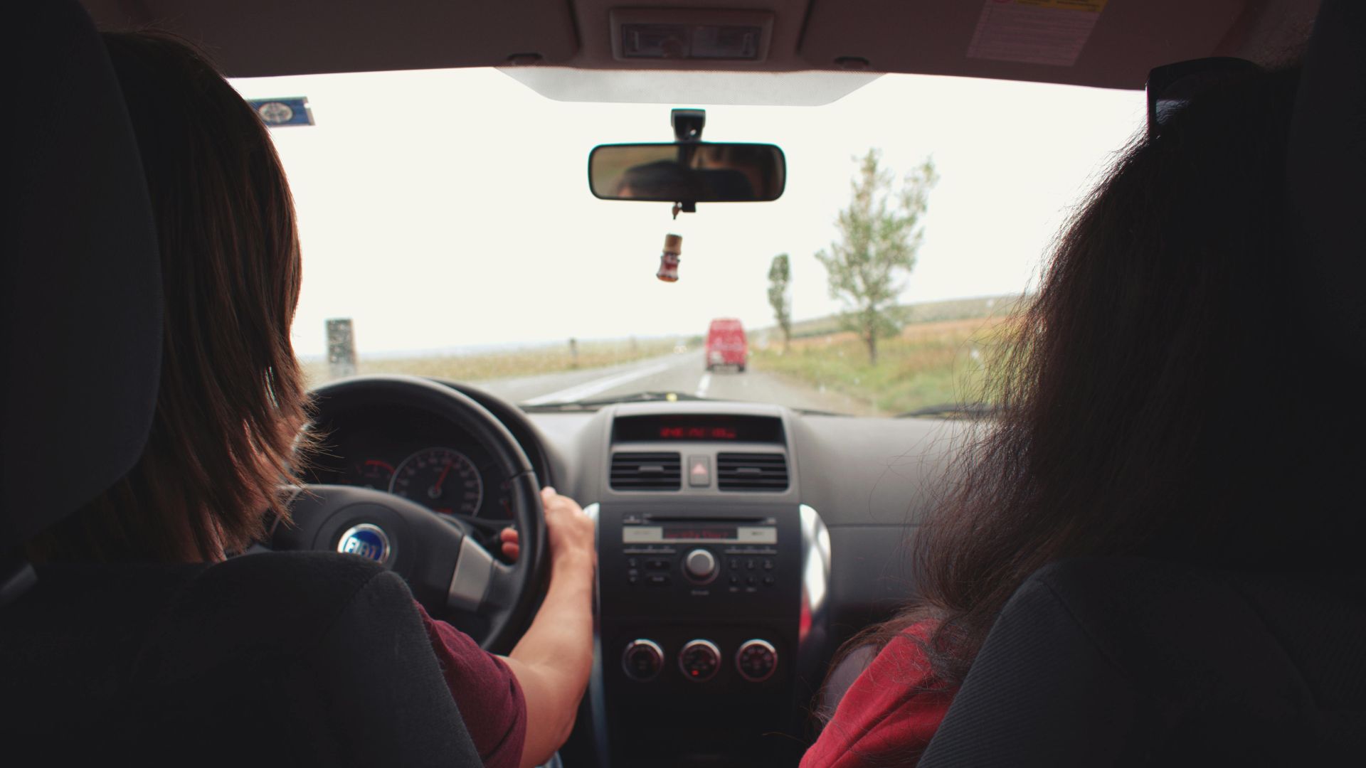 Two adults traveling by car on a scenic road near Iași, Romania.