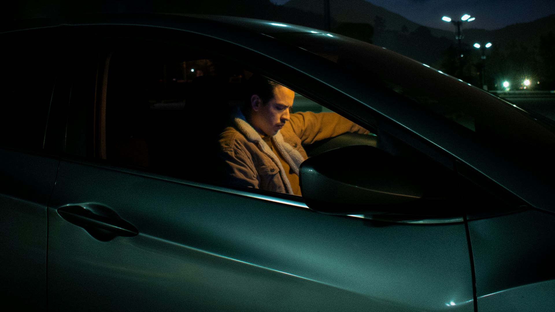 a man sitting in a car at night