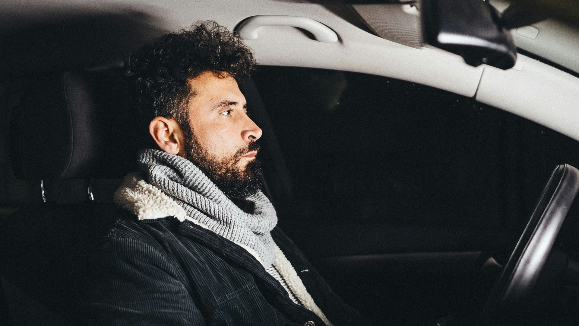 a man driving a car in the dark