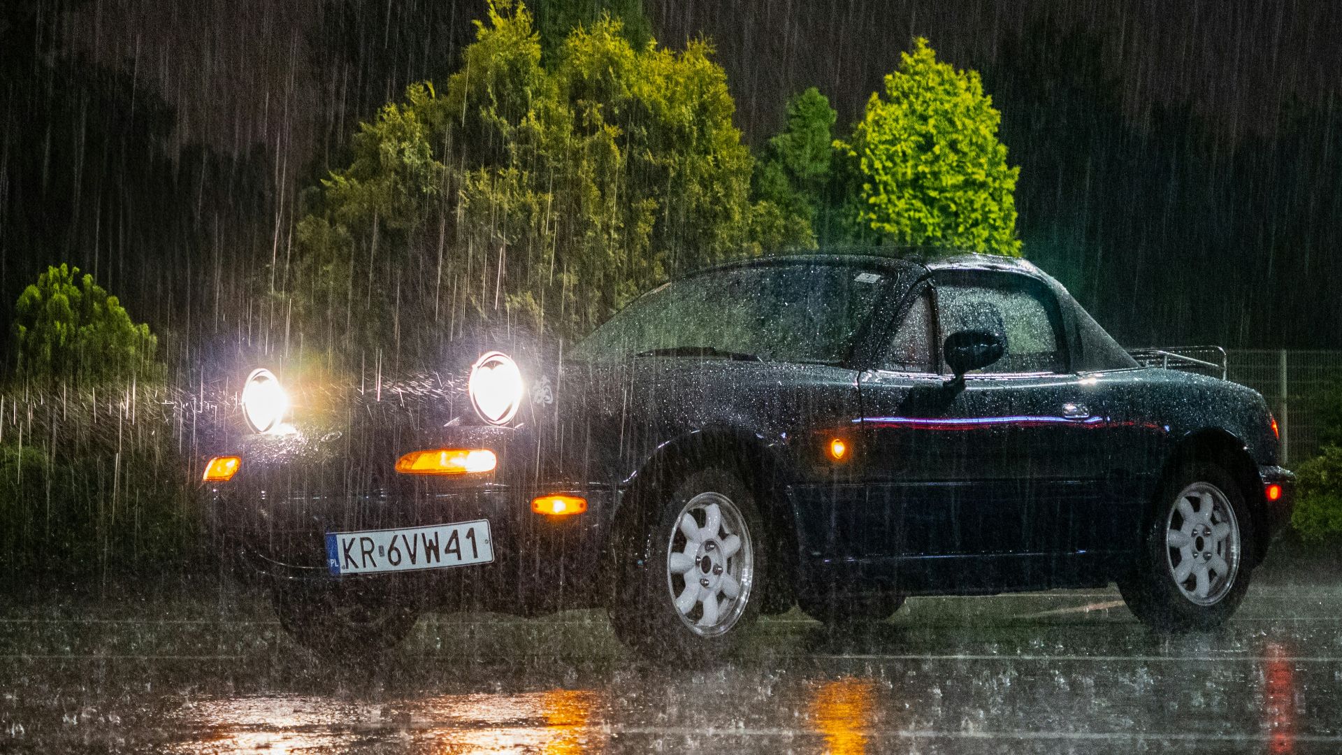 A car driving in the rain at night