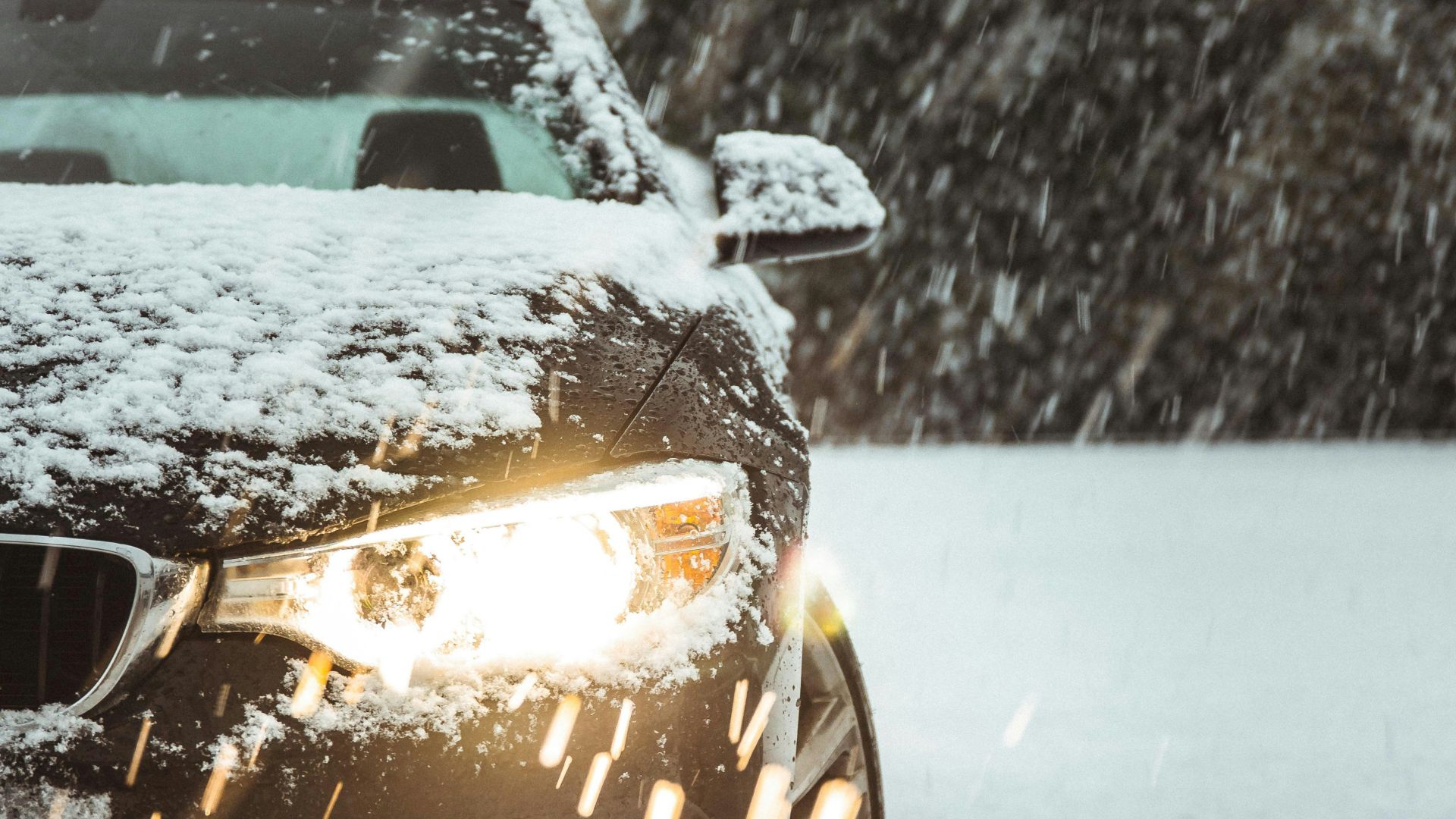 black car on snow covered road during daytime