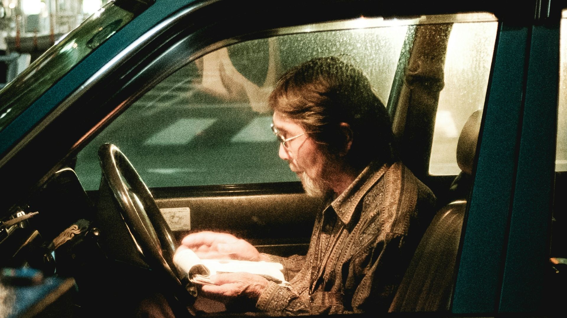 grayscale photo of man in car