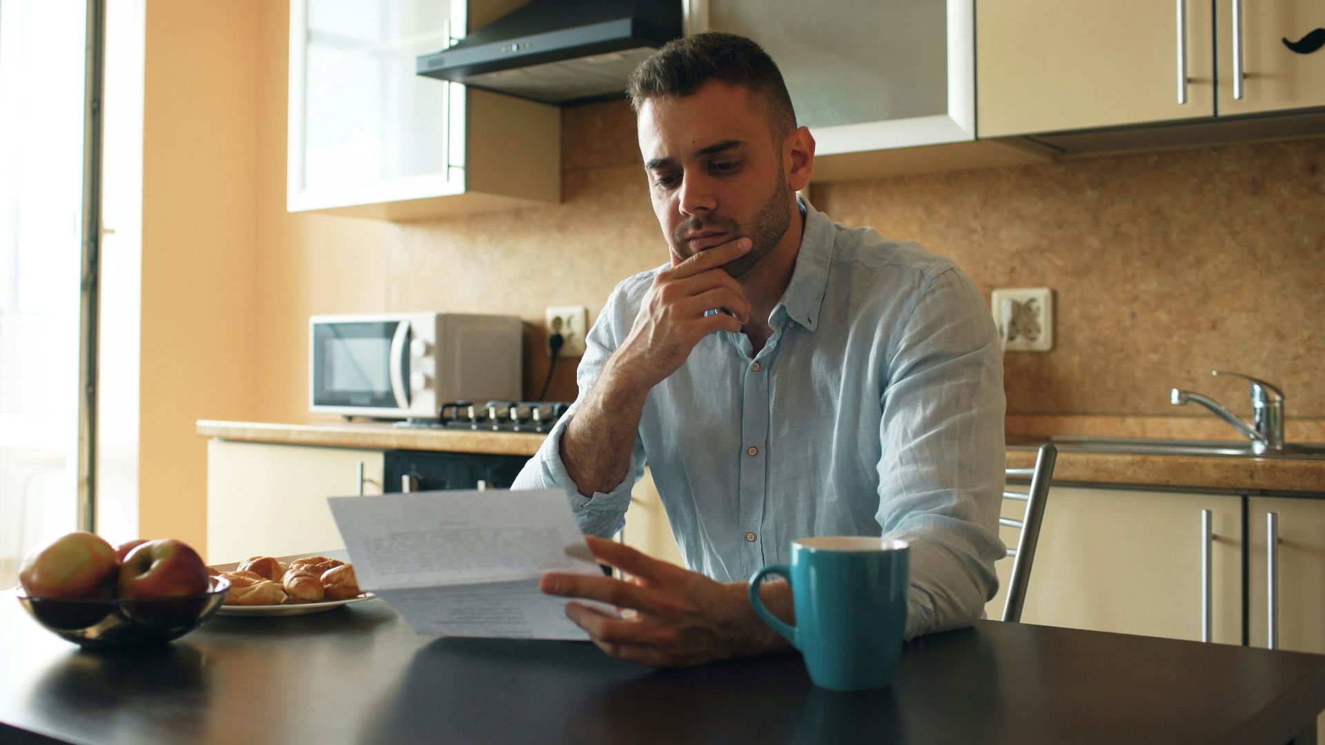 Man reading a document in a kitchen
