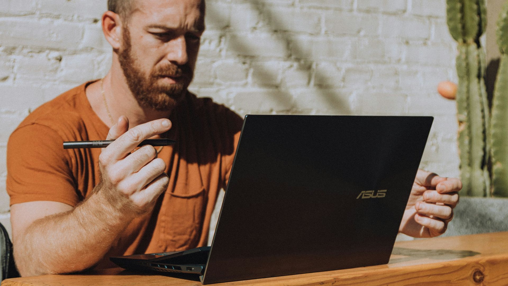a man sitting at a table using a laptop computer
