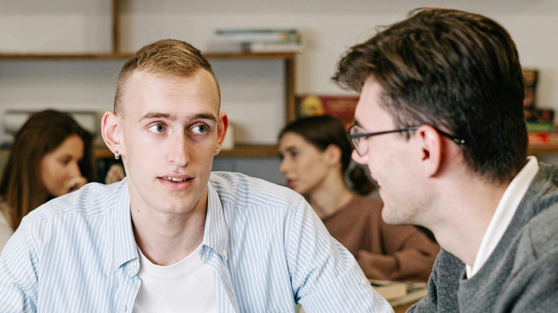 Group of young adults discussing in a study group indoors, focusing on teamwork and learning.