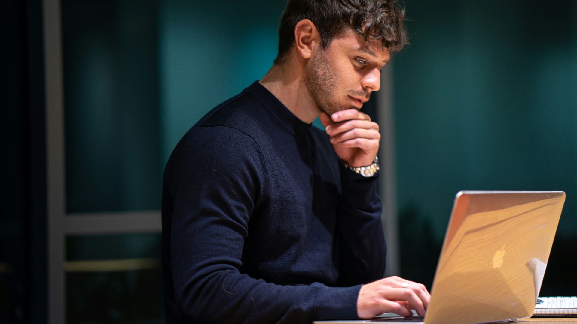 man in black long sleeve shirt sitting in front of macbook