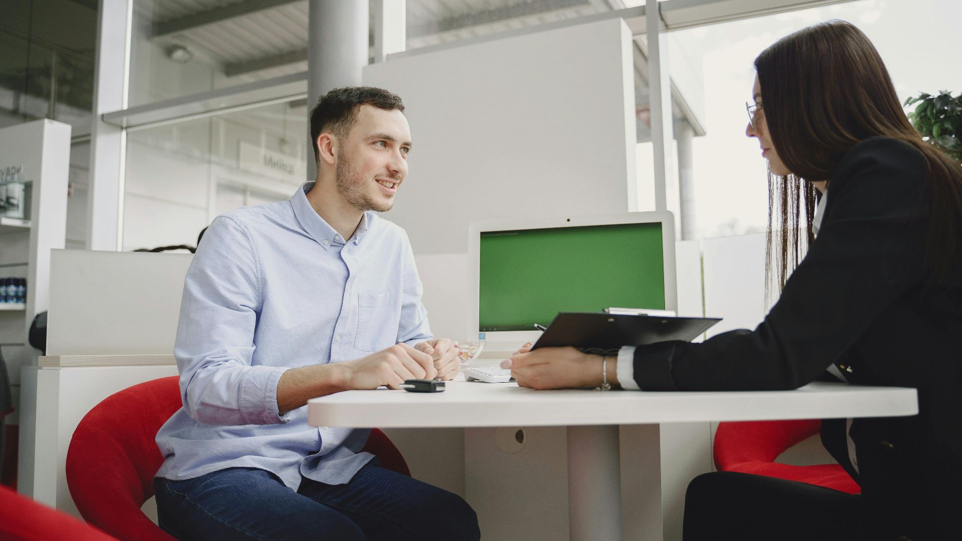 A man and woman engaged in a professional meeting at a modern office table.