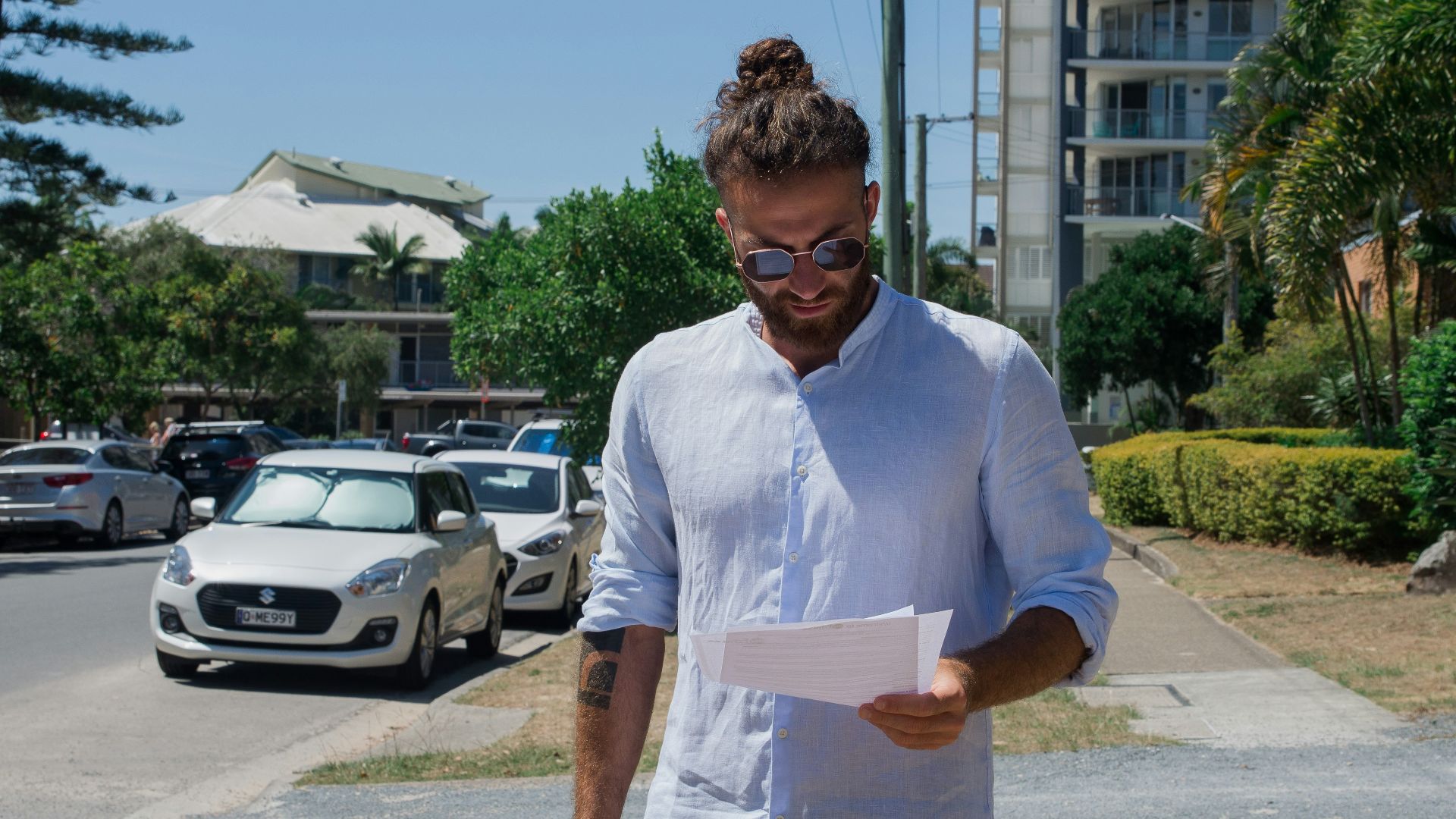 man in white button up t-shirt holding white printer paper