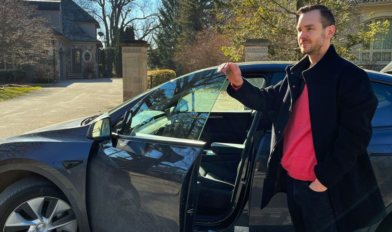 a man standing next to a car with its door open