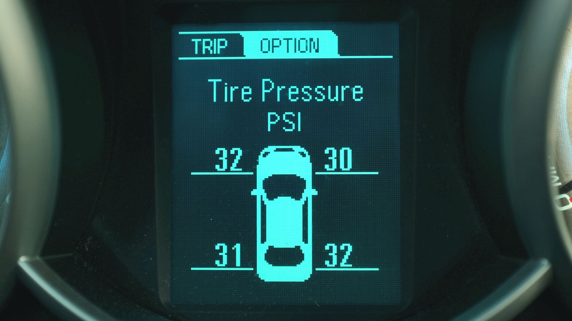 Electronic Driver Information Center (DIC) in a 2013 Chevrolet Cruze displaying pressure measurements reported by the Tire Pressure Monitoring System (TPMS). Measured pressure for each tire is displayed in pounds per square inch (PSI). Pictograph of vehicle shows which measurement corresponds to each tire.