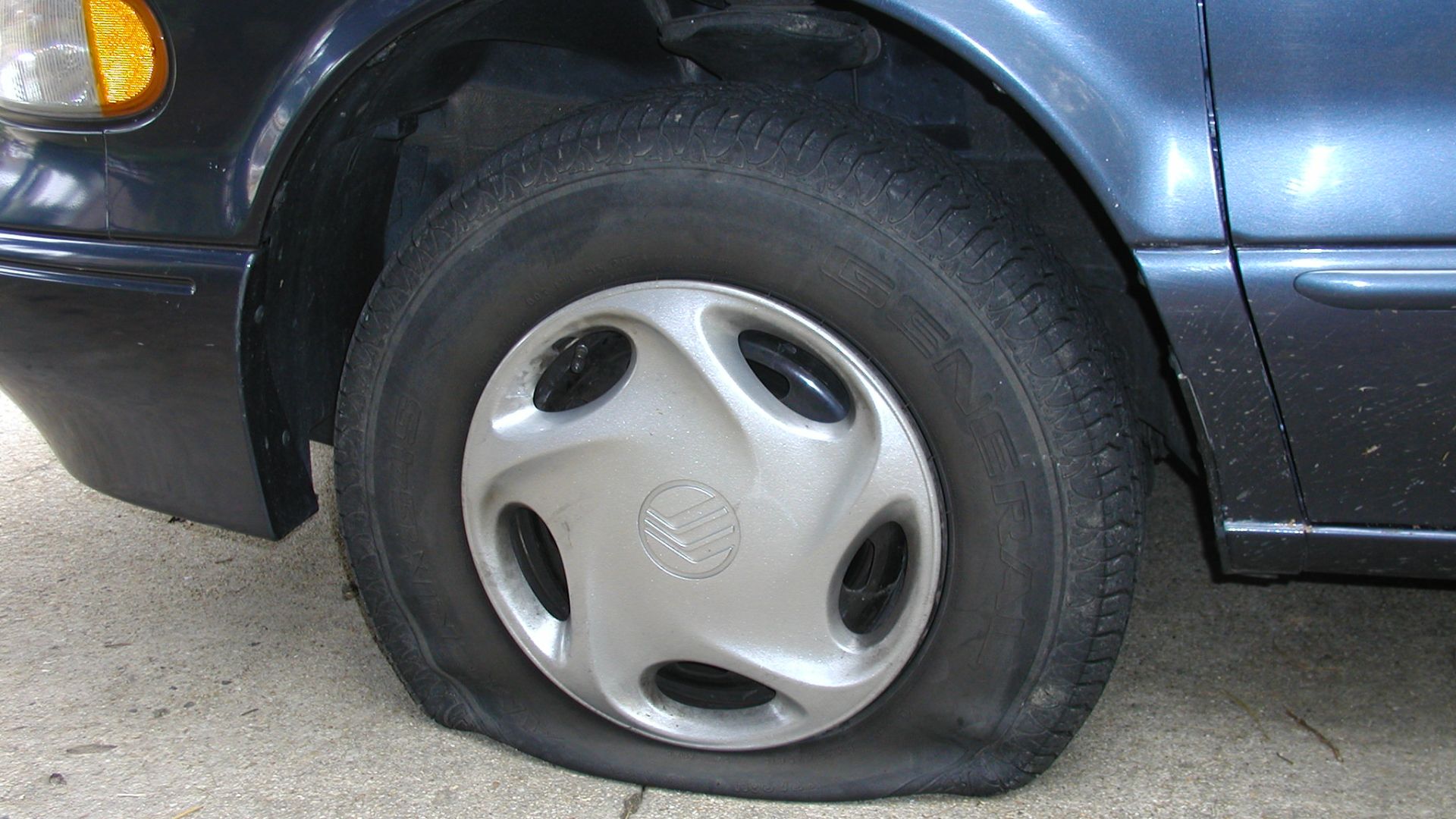 A flat tire on a Mercury Villager van.
