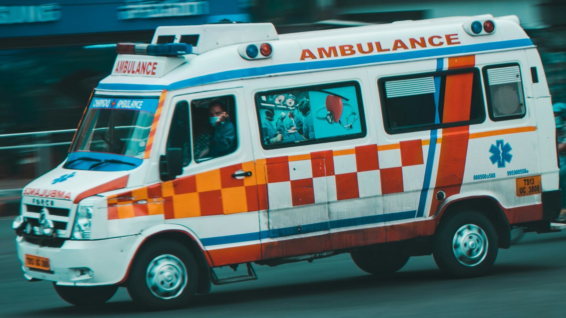 an ambulance driving down a street next to tall buildings