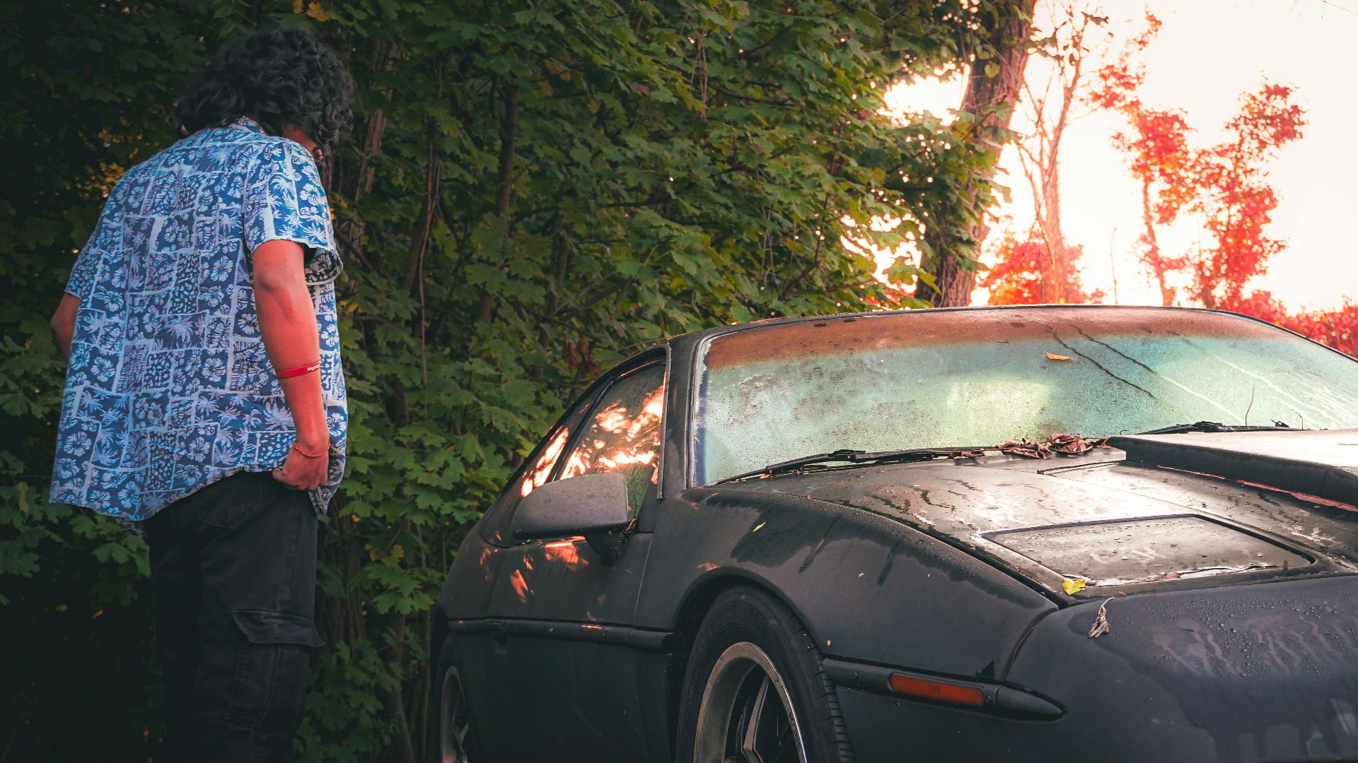 A person standing next to a parked car