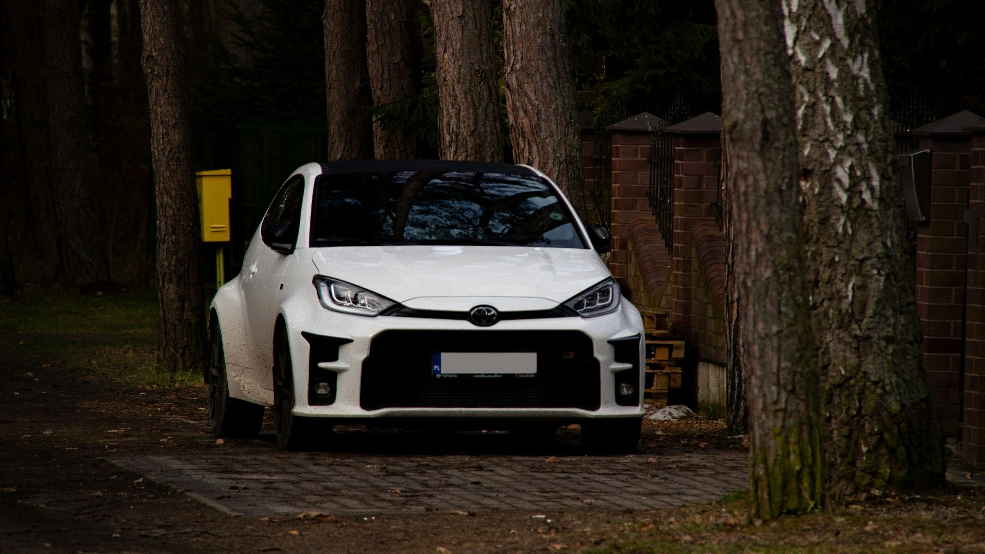 a white car parked in front of some trees