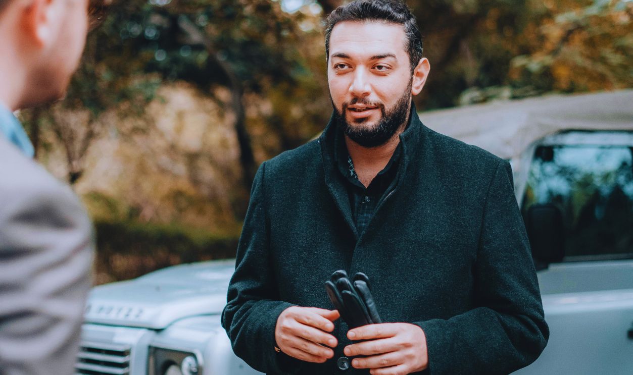 Men Talking and an Off-road Car in the Background