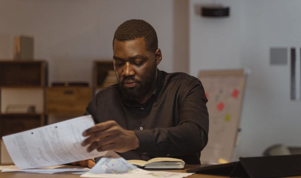 Man in Black Long Sleeve Shirt Holding White Paper