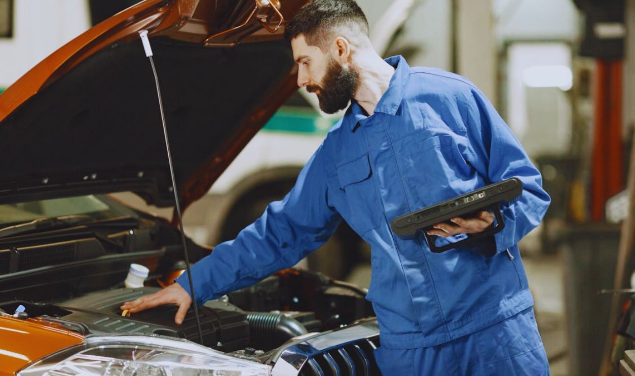 Mechanic Checking the Engine of a Car
