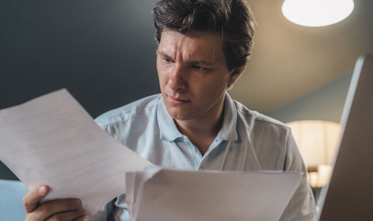 A Man Holding Printer Papers