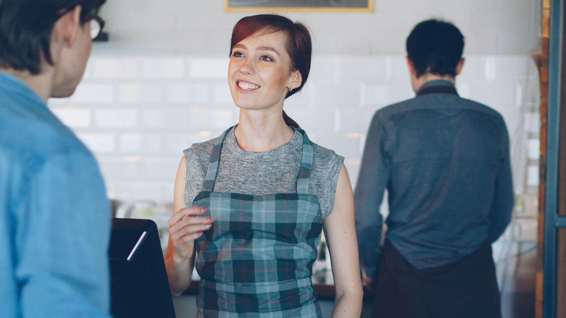 A barista is talking to a customer.