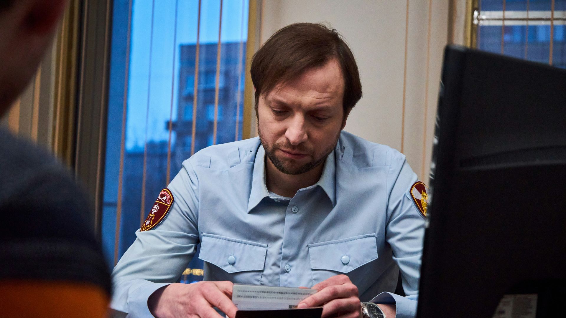 woman in blue button up shirt sitting at the table