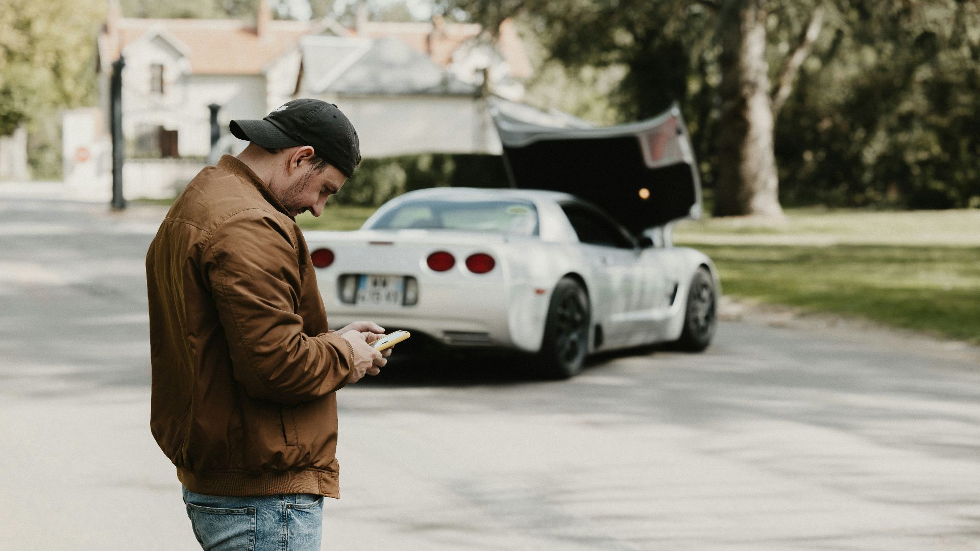 a man standing in the street looking at his cell phone