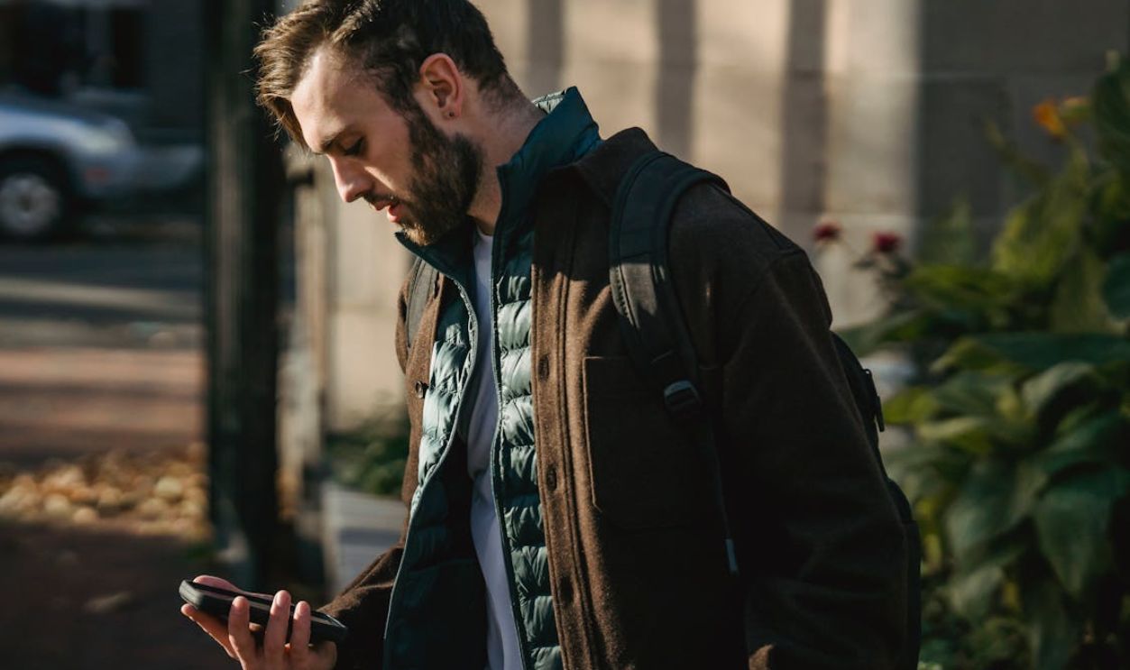 Guy using phone in city street