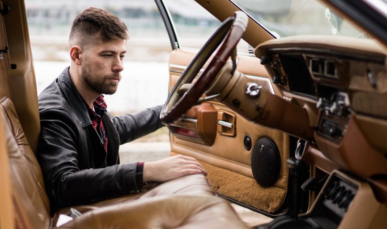 Male driver near vehicle with open door in street