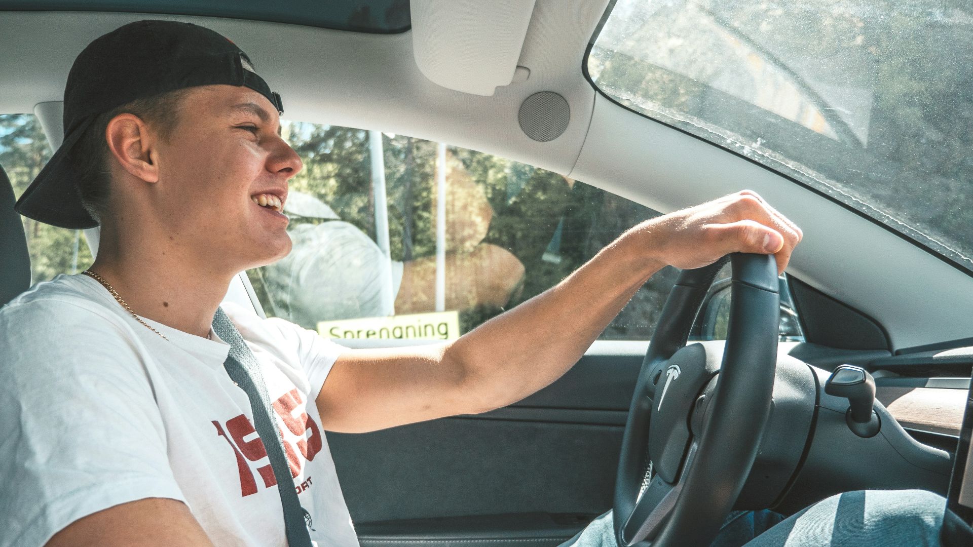 man in white crew neck t-shirt driving car