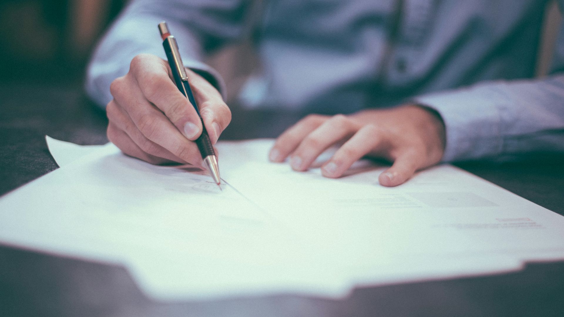 man writing on paper