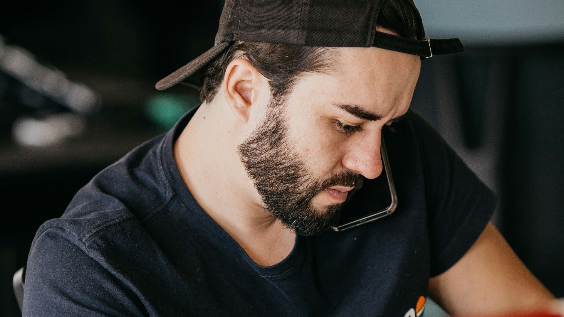 a man with a beard looking at a computer monitor