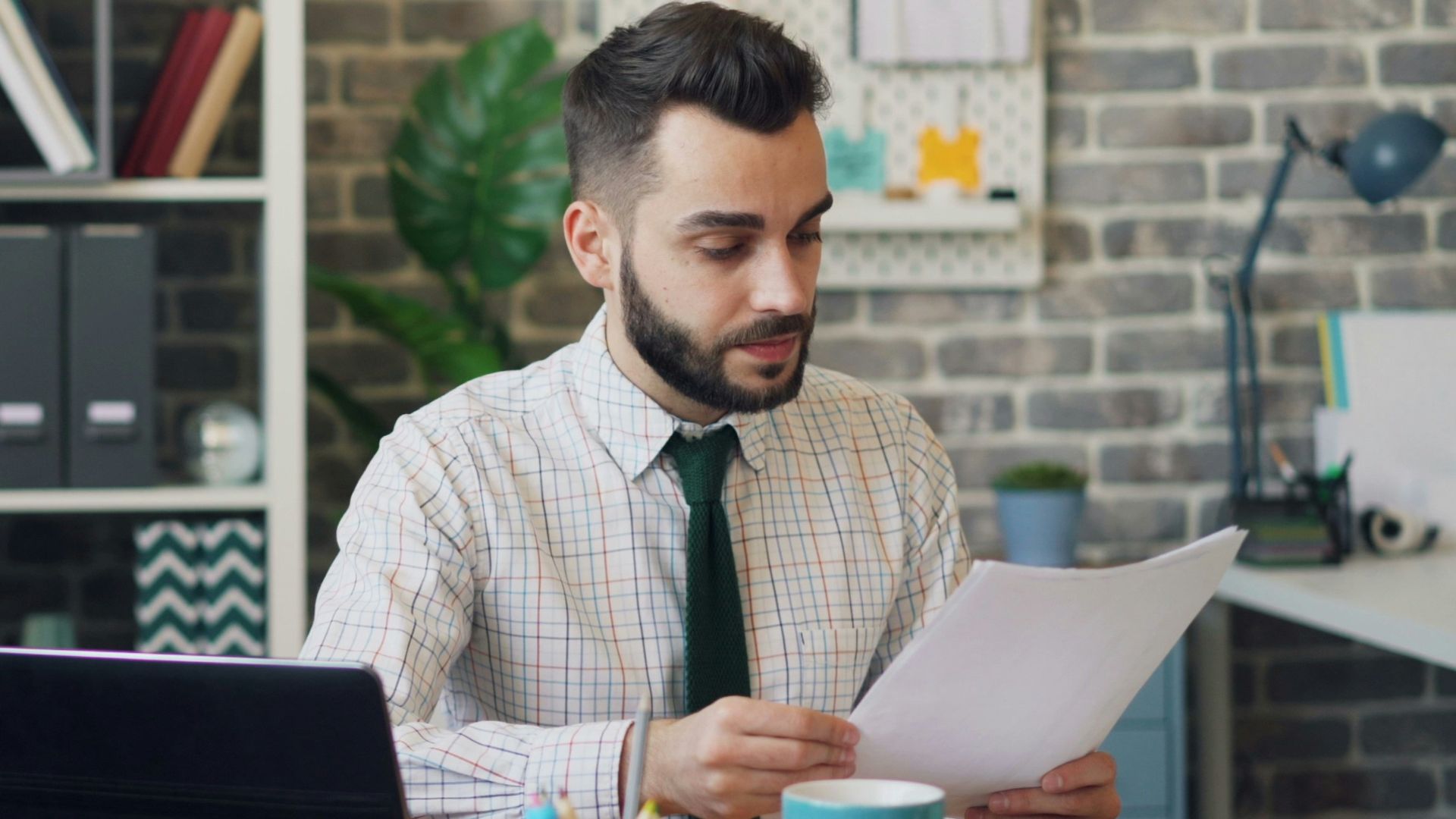 a man sitting at a desk in front of a laptop