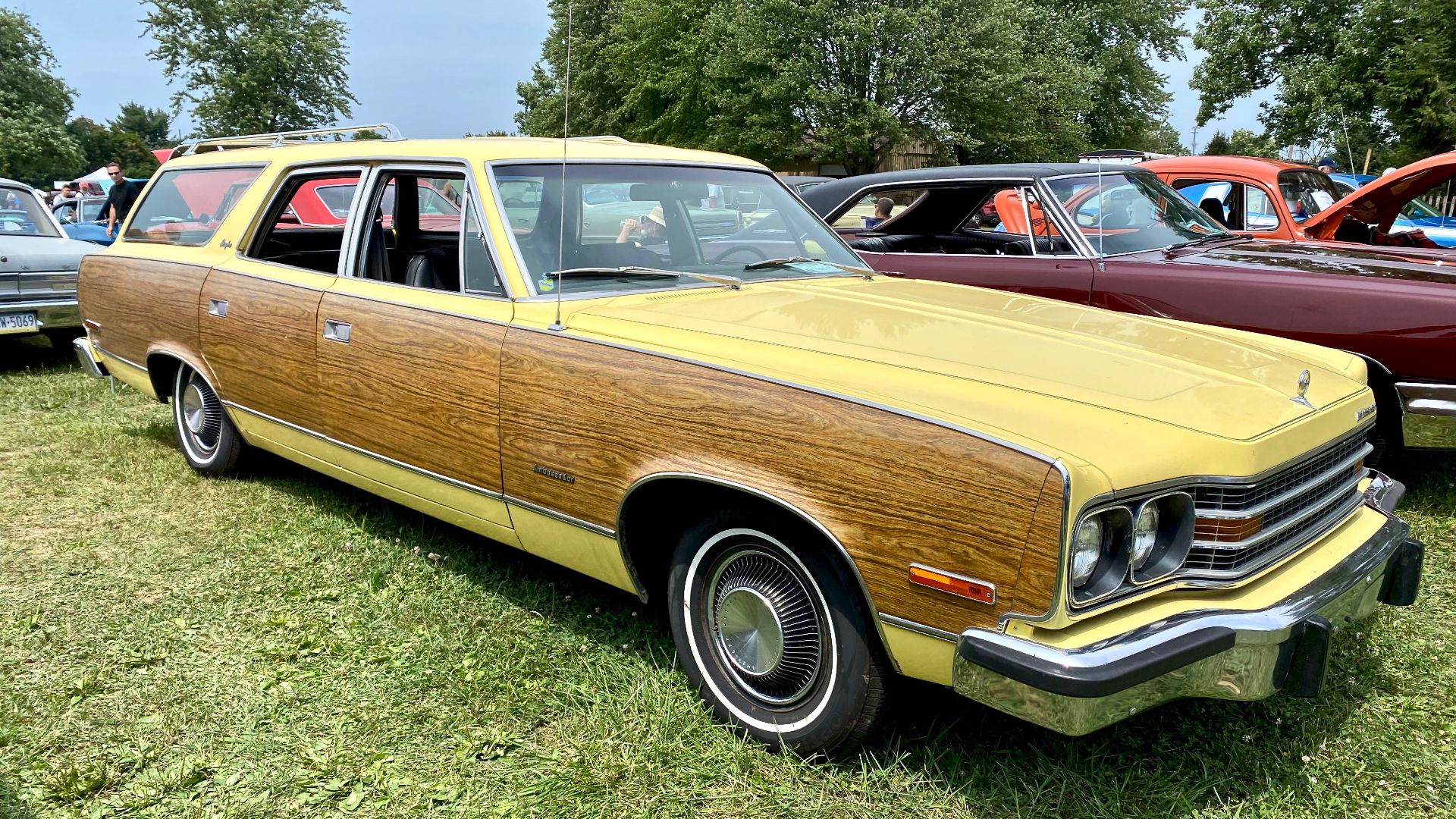 1974 AMC Ambassador Brougham station wagon. A full-sized luxurious car built by American Motors Corporation (AMC). This was the last model year for the Ambassador, at the time it was one of the longest continuous automobile nameplates - used since 1932). All Ambassadors were equipped with V8 engines, automatic transmissions, power steering and disk brakes, air conditioning, radio, and numerous other standard comfort features. Interiors featured luxurious upholstery and trim as well as 50-50 individually adjustable and reclining front seats. This car is finished in Daisy Yellow (paint code F4) with woodgrain bodyside trim and interior in black. The photographs were taken at the 2021 Das Awkscht Fescht Car Show in Macungie Pennsylvania.