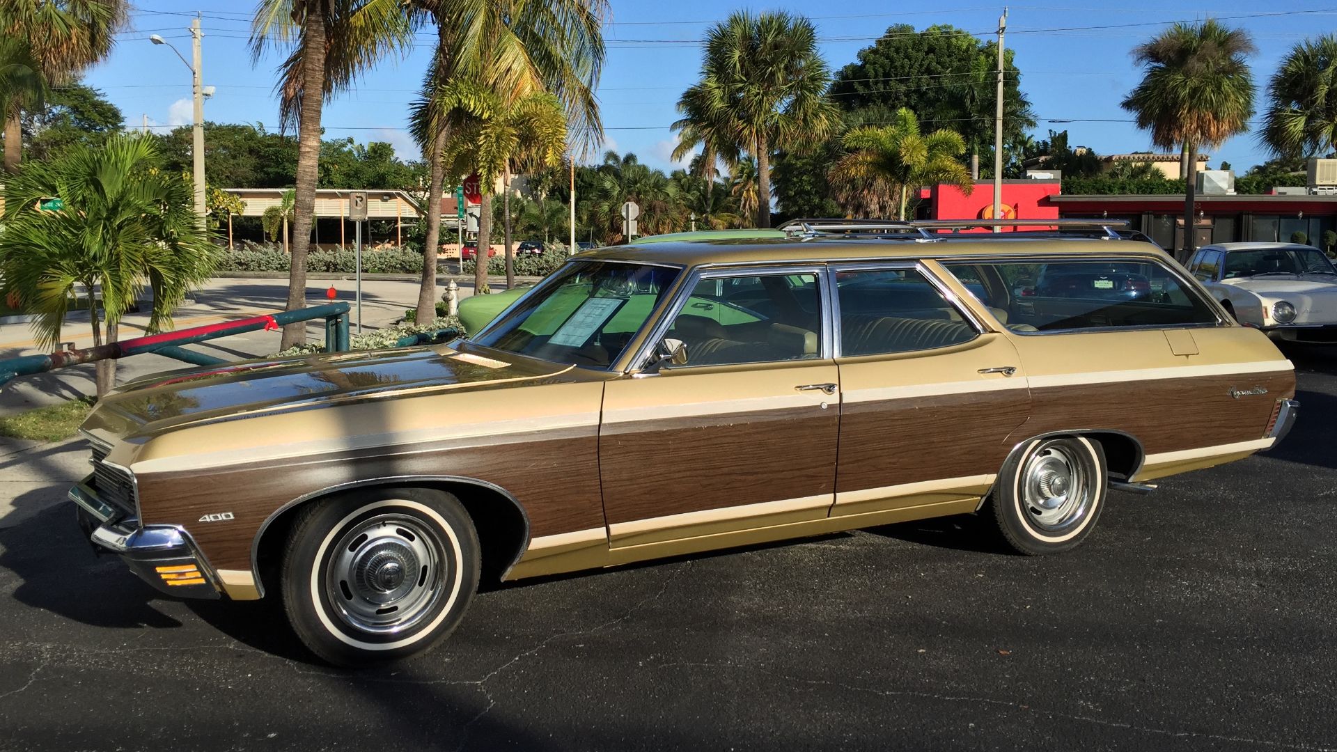 1970 Chevrolet Kingswood Estate. A surviving original factory condition four-door station wagon with three rows of seats, with the rearmost one facing backwards. Finished in beige with woodgrain paneling trim on bodysides and tailgate. This car also has the optional 400 CID (6.55 L) V8 engine.