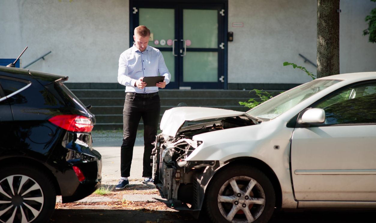 Insurance Investigator Analyzing Car Accident Claim On Tablet Device