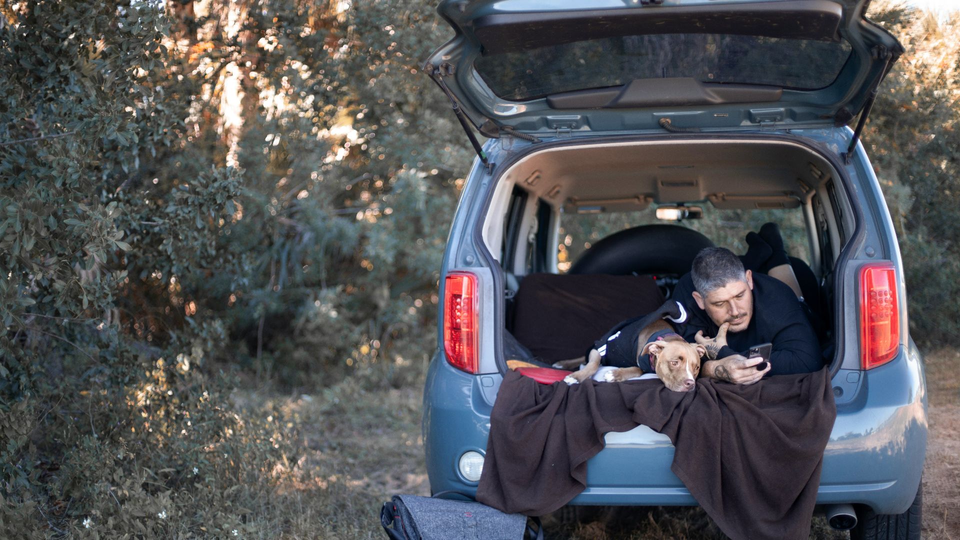 a man sitting in the back of a blue van