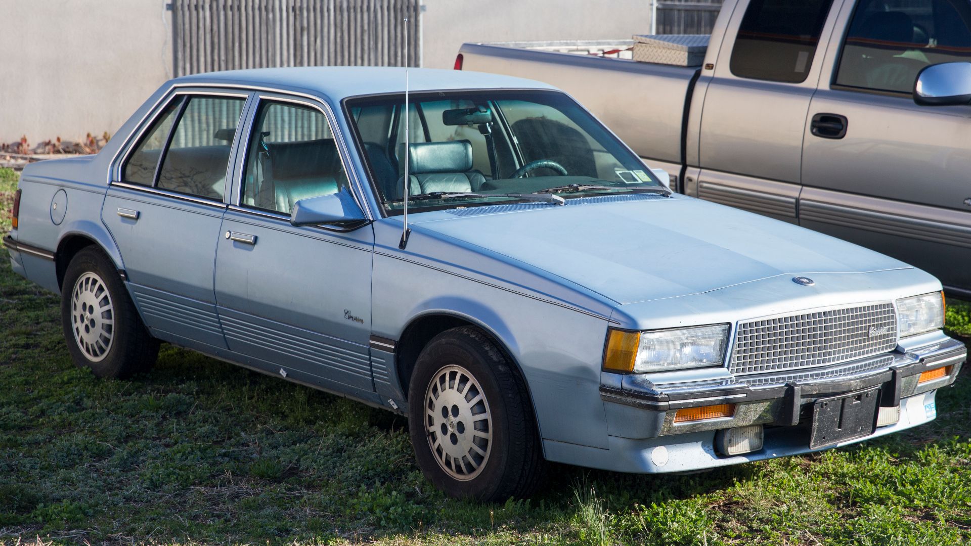 1988 Cadillac Cimarron with the 2.8-liter V6. Built in Janesville, WI. Sadly missing much of the trim along the sides, but might still prove a useful photo for something. Maybe.