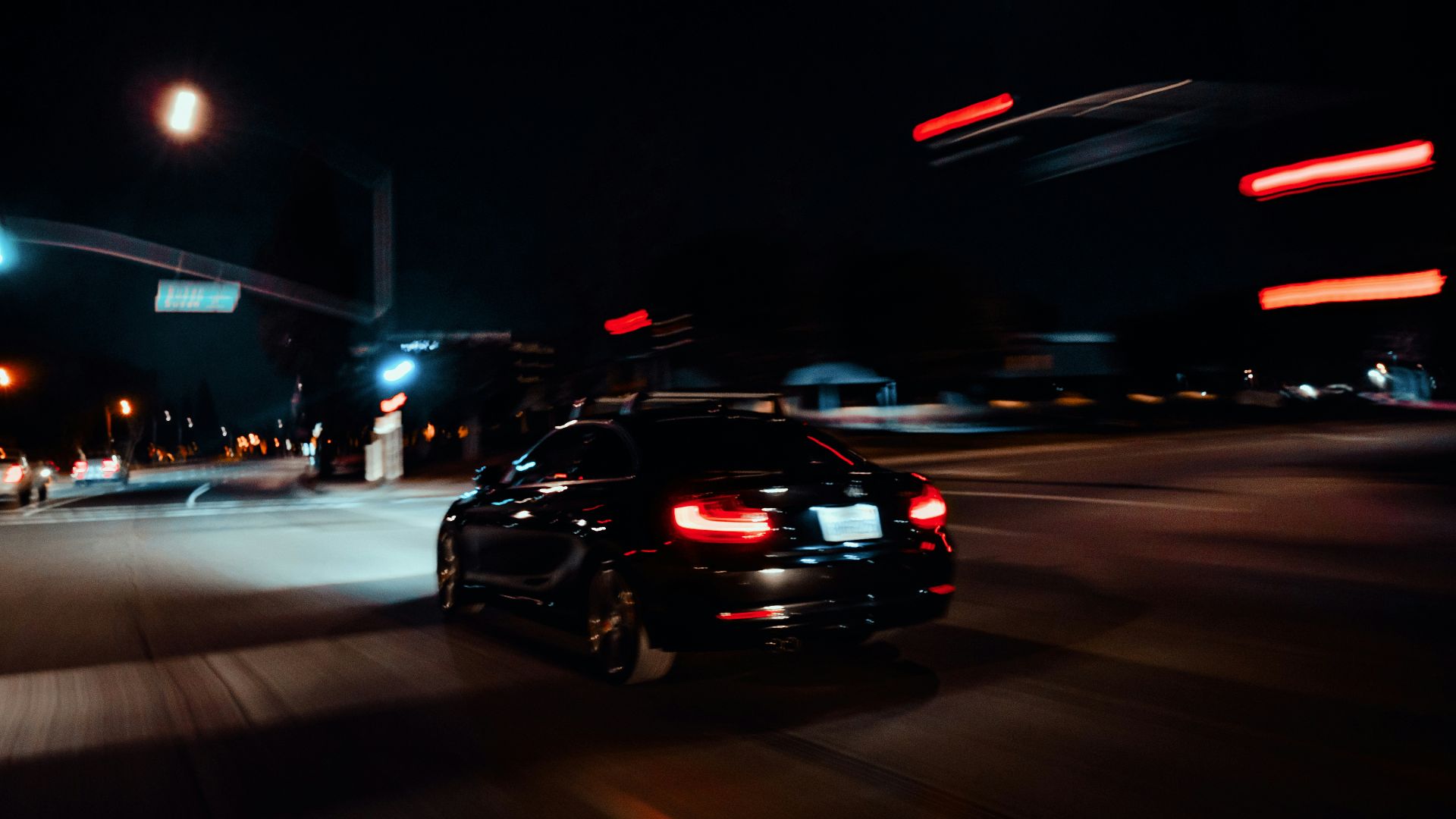 a car driving down a street at night